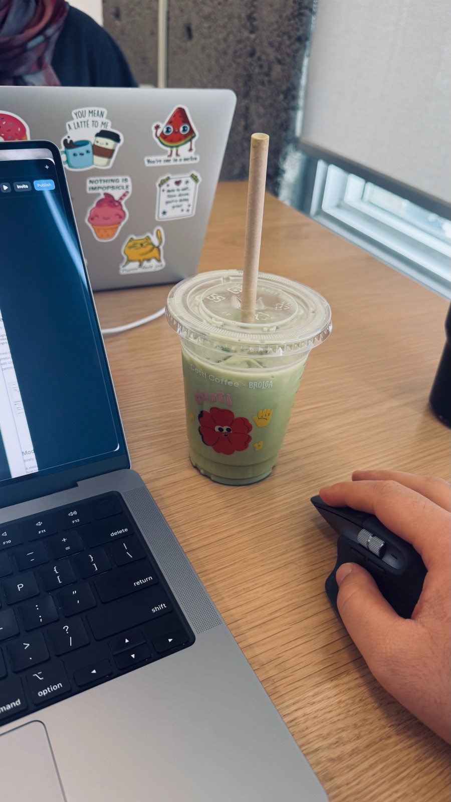 A laptop, a mouse and an iced matcha on a desk