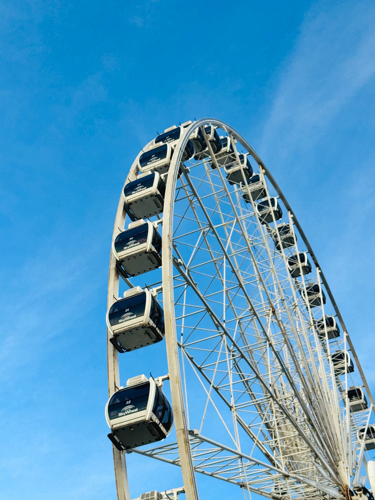A white Ferris wheel against a blue sky