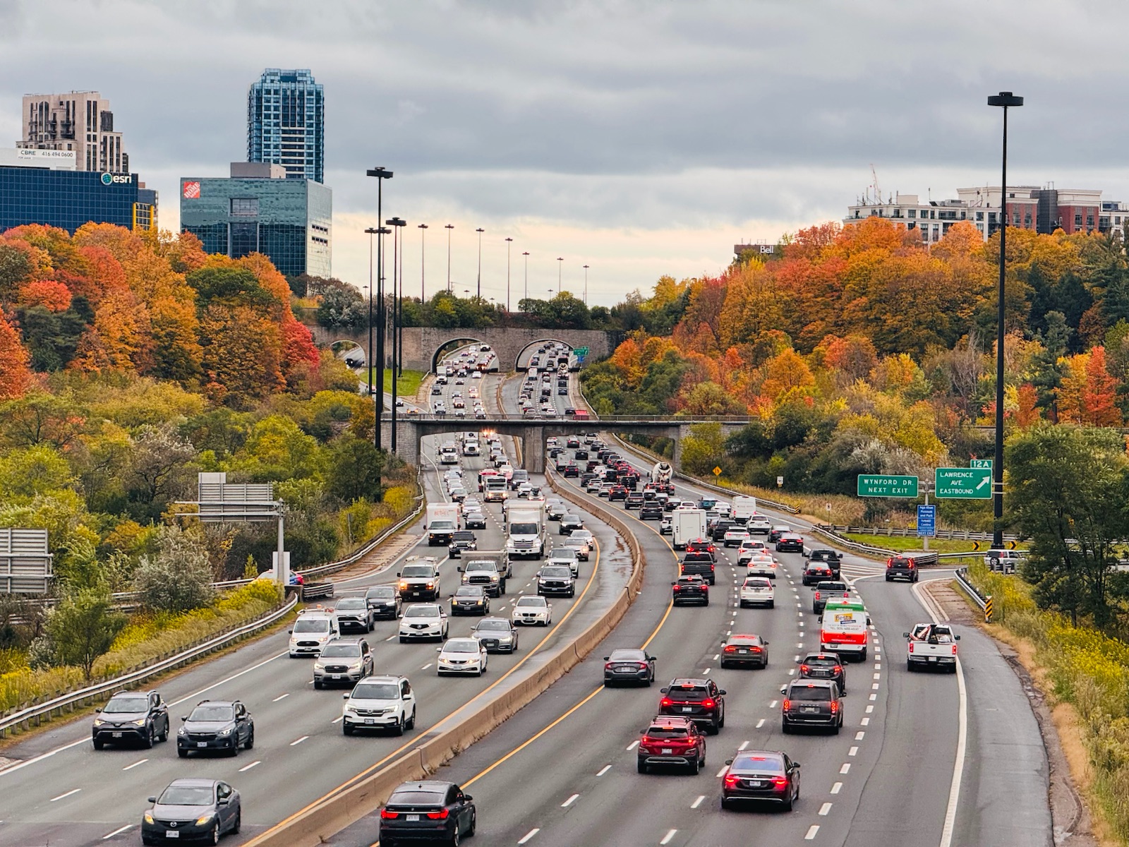 Traffic on a highway lined with autumn trees