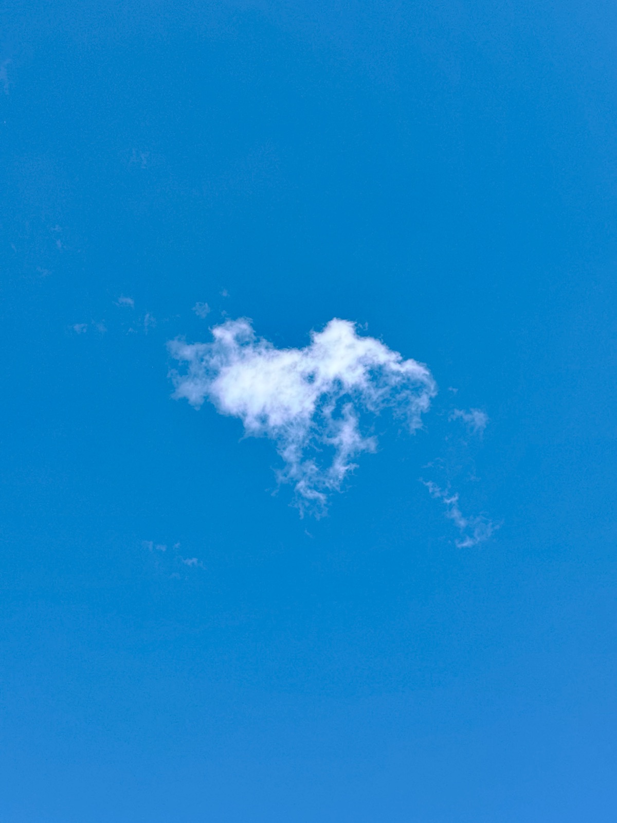 A single small cloud in a clear blue sky