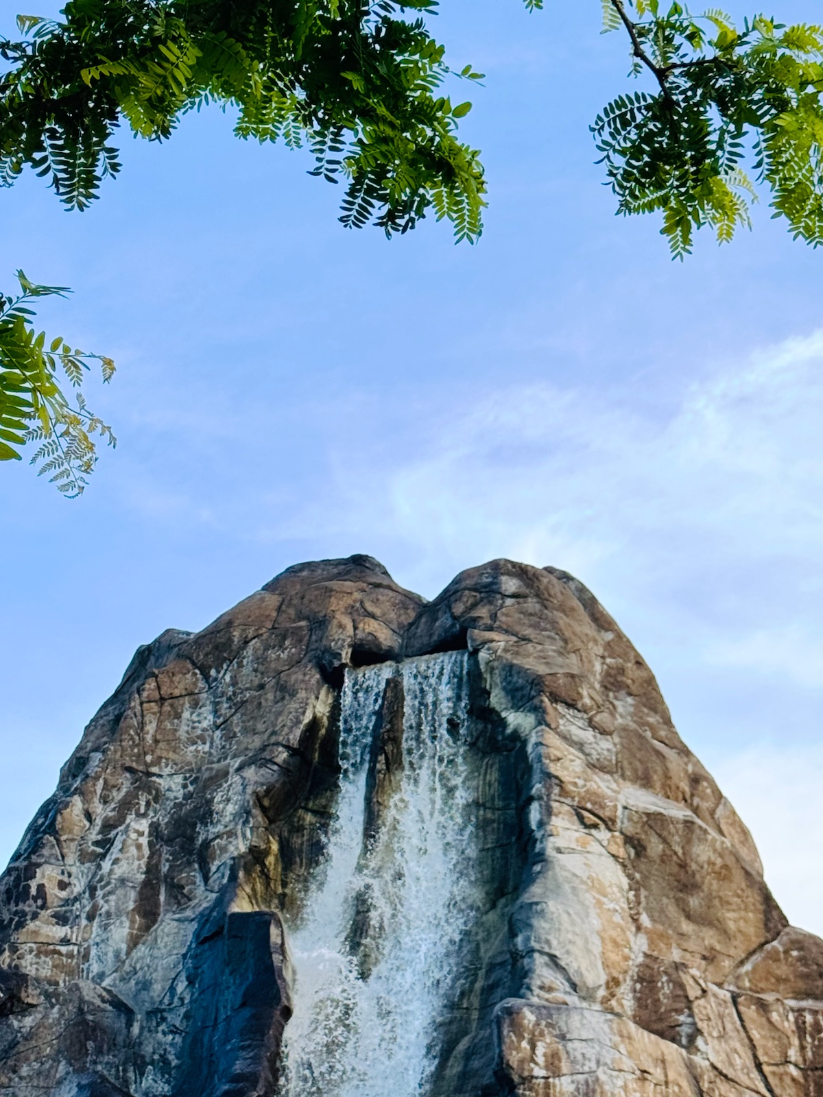 A rock peak with a waterfall under a blue sky